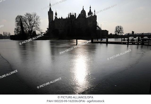 20 Febuary 2018, Germany, Schwerin: The sun is mirrored on the ice of Lake Schwerin in front of the castle. Photo: Bernd Wüstneck/dpa-Zentralbild/dpa