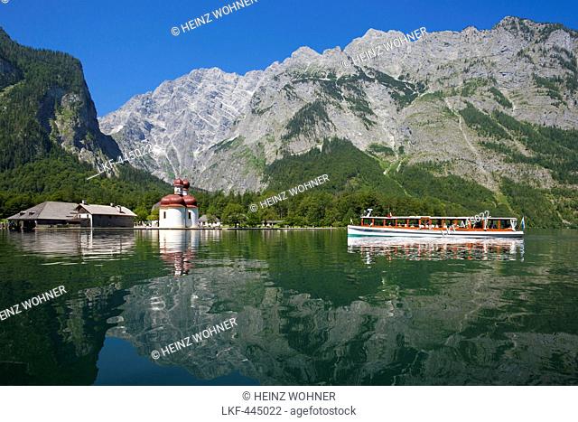 Excursion boat in front of baroque style pilgrimage church St Bartholomae, Watzmann east wall in the background, Koenigssee, Berchtesgaden region