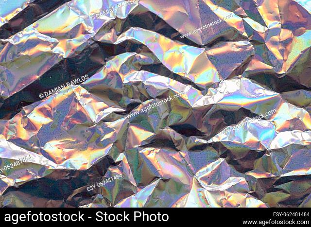 Abstract trendy holographic background. Fantasy texture in soft colors and irregular wrinkled shapes