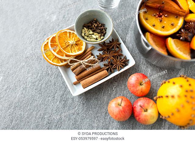 pot of hot mulled wine, orange, apples and spices