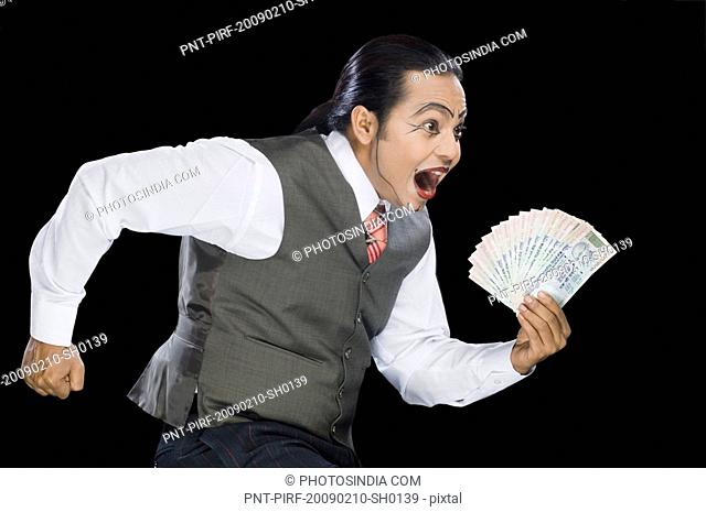 Close-up of a mime running with currency notes