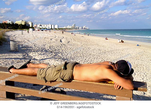Florida, Miami Beach, South Pointe Park, Atlantic Ocean, man, sunbathing, tanning, lying down, sand, public beach, surf,