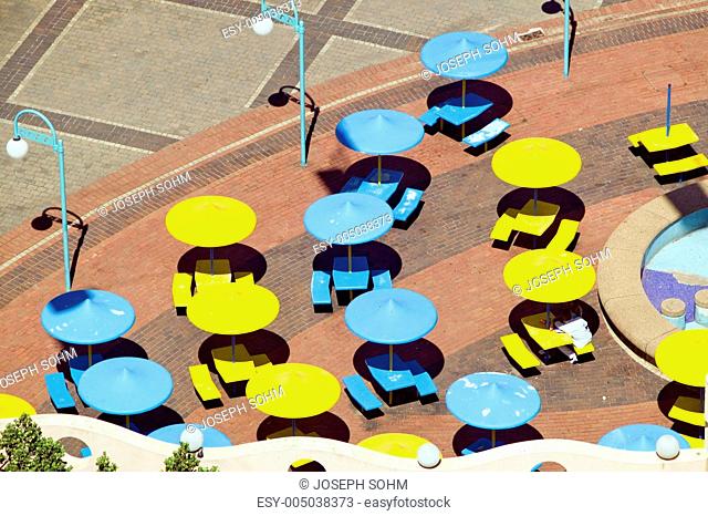 Elevated perspective of brightly colored yellow and blue umbrellas along Indian Ocean front of Durban, South Africa