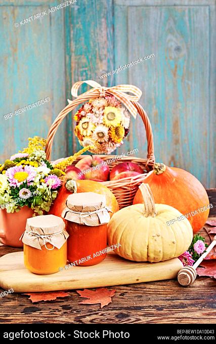 Glass jars with pumpkin jam and honey. Fresh vegetables on the table. Healthy food