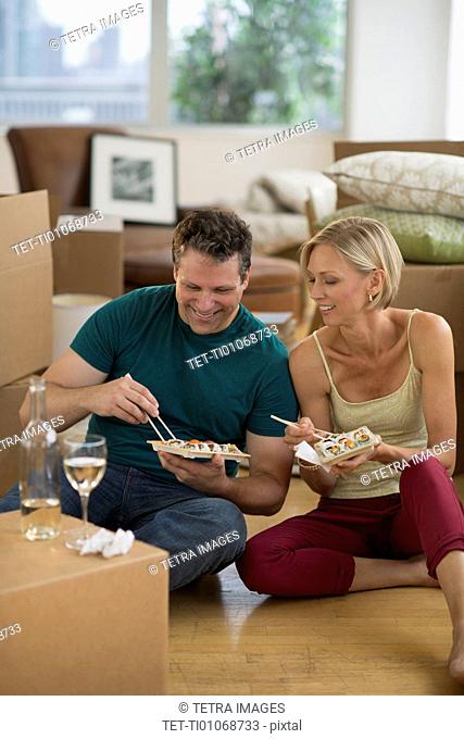 Couple eating sushi in new home