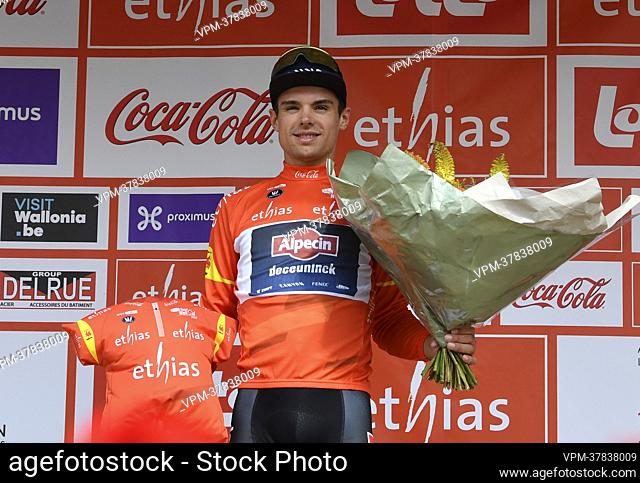 Australian Robert Stannard of Alpecin-Deceuninck celebrates on the podium wearing the orange jersey of leader in the overall ranking during the third stage of...