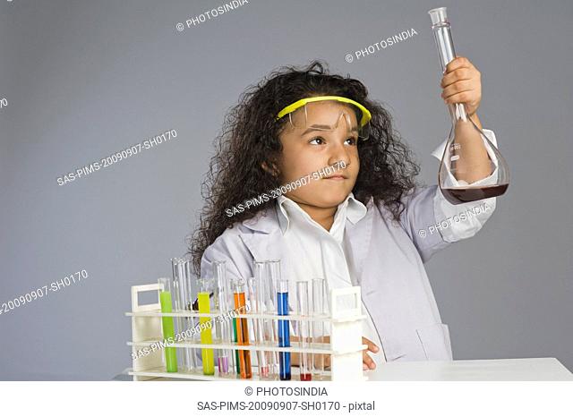 Girl dressed as scientist researching in the laboratory