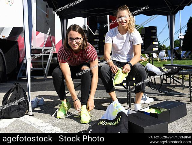28 June 2021, Bavaria, Munich: Judokas Theresa (r) and Amelie Stoll try on new shoes while dressing part of the German Olympic team