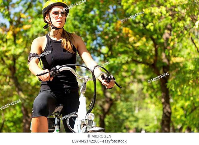 Young woman with cycling helmet on a bike