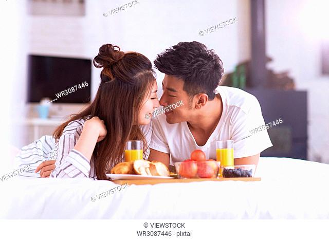 Young couples have breakfast in bed