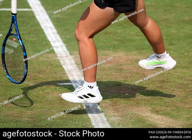 26 June 2023, Hesse, Bad Homburg: Tennis: WTA Tour, Singles, Women, 1st Round Andreescu (CAN) - Kartal (GBR). Sonay Kartal's shadow can be seen on the grass