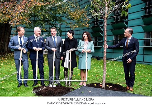 17 October 2019, Berlin: Heiko Maas (r, SPD), Foreign Minister, is symbolically planting a tree at the 20th anniversary celebrations of the Nordic Embassies in...