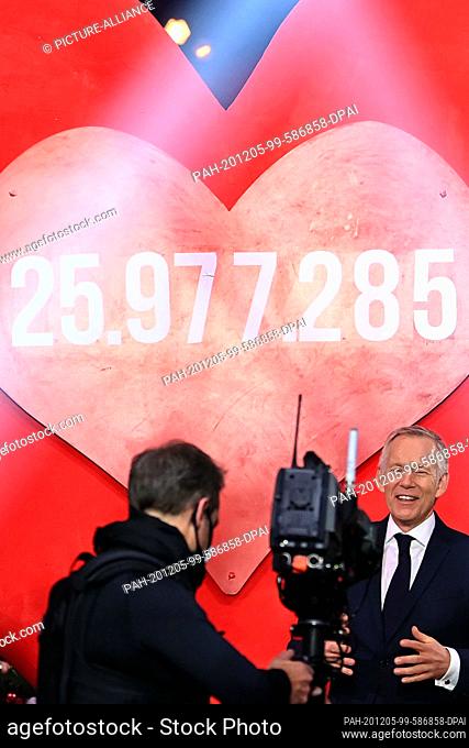 05 December 2020, Berlin: Presenter Johannes B. Kerner (r) presents the final donation on a big red heart of 25 977 285 Euro at the TV donation gala ""Ein Herz...