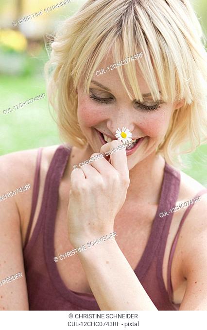 woman holding flower smiling