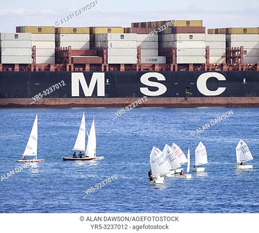 Las Palmas, Gran Canaria, Canary Islands, Spain. Container ship passing close to small dinghies as it enters Las Palmas port