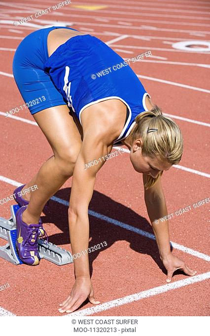 Female athlete in starting block ready to run