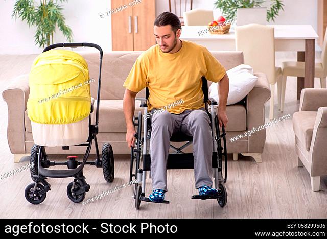 Young man in wheel-chair looking after newborn