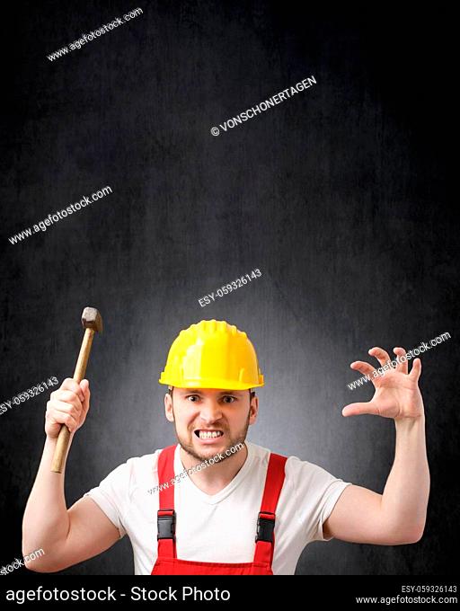 Angry construction worker with a hammer in his hand