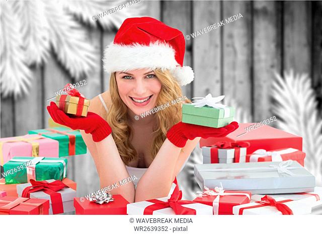 Happy woman in santa hat holding christmas gifts