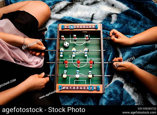 photo of a mother playing with her son with a football table