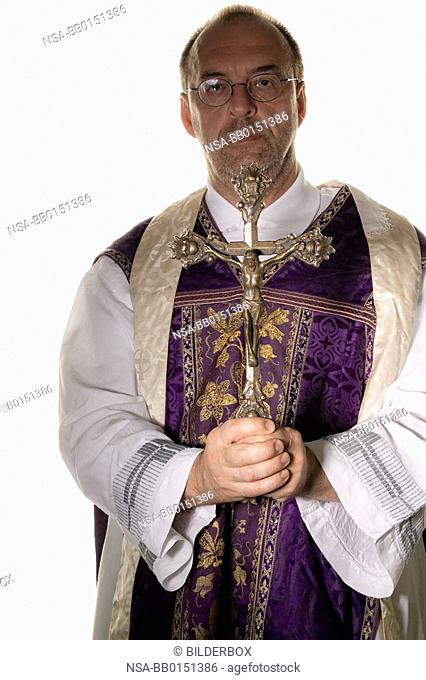 a Catholic priest with a cross in worship