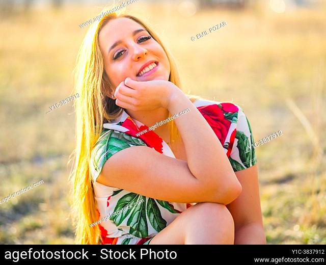Adolescent blonde girl happy close-up portrait giggling at camera