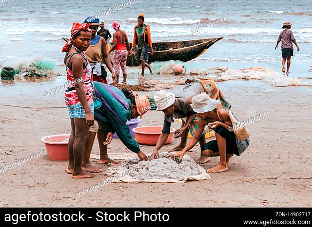 MAROANTSETRA, MADAGASCAR OCTOBER 19.2016: Native woman sort catch on beach after fishing. Daily life of indigenous peoples in Madagascar countryside