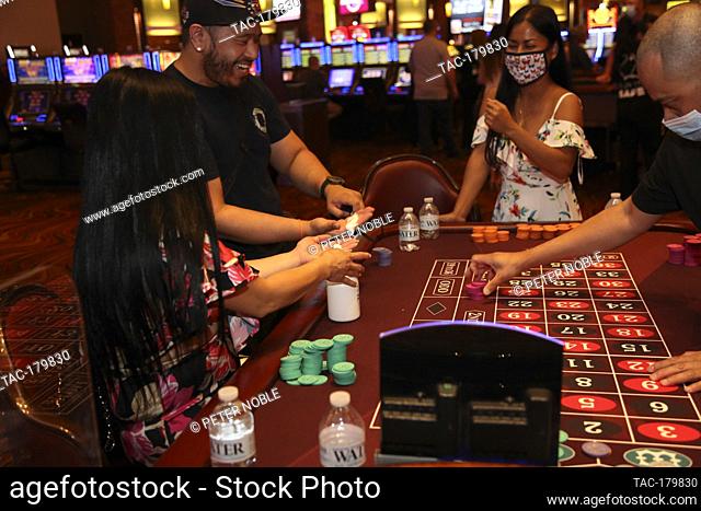 Las Vegas, NV - June 4, 2020: Players share hand sanitizer before high fives during the Grand Re-Opening of Red Rock Casino Resort & Spa at 12:01 AM on June 4
