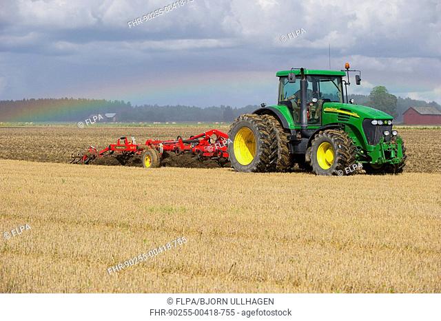 John Deere 7720 tractor with Vaderstad 560 flexible cultivator, cultivating stubble field, Sweden, august