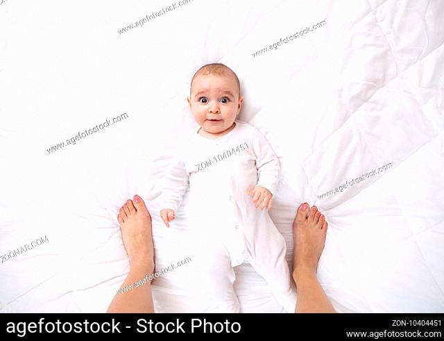 Happy addorable baby boy and the legs of his mother who taking a portrait of him