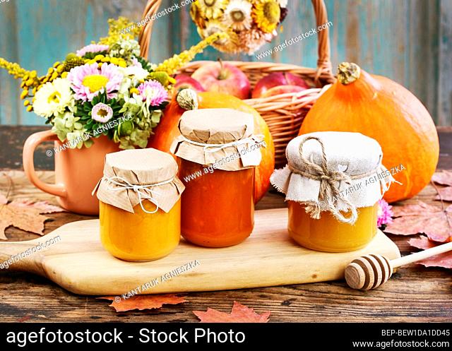 Glass jars with pumpkin jam and honey. Fresh vegetables on the table. Healthy food