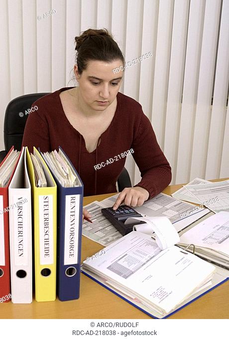 Woman in office, document files, filling formular