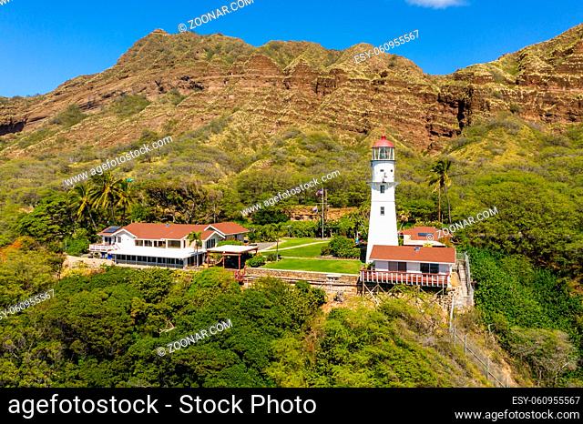 Aerial view of old white lighthouse under Diamond Head on Oahu from the ocean