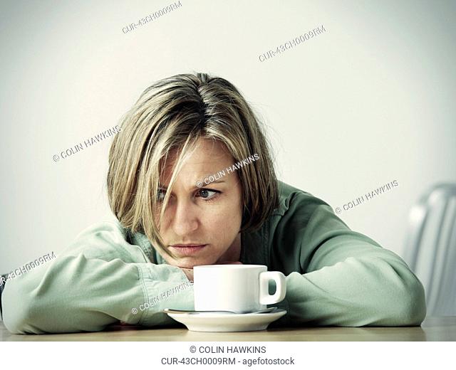 Woman resting head in hands at desk