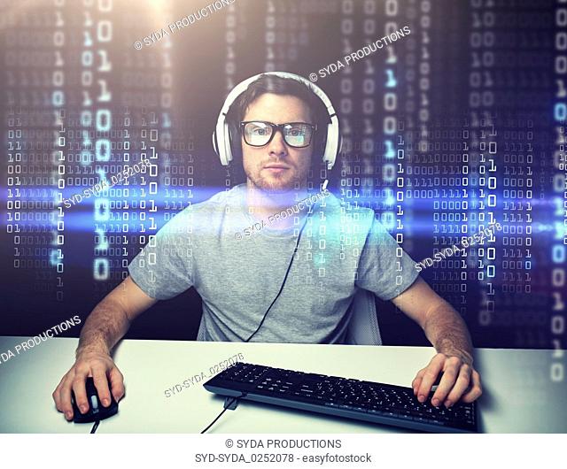 man in headset hacking computer or programming