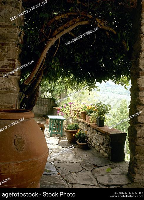 A detail of a rustic paved terrace area with pots
