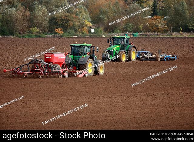 05 November 2023, Saxony-Anhalt, Derenburg: A field is fertilized and drilled with tractors. Farmers use the weather to prepare their fields for spring