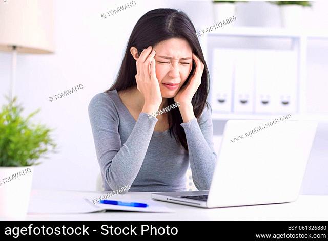 Stressed young woman suffering from headache after computer work
