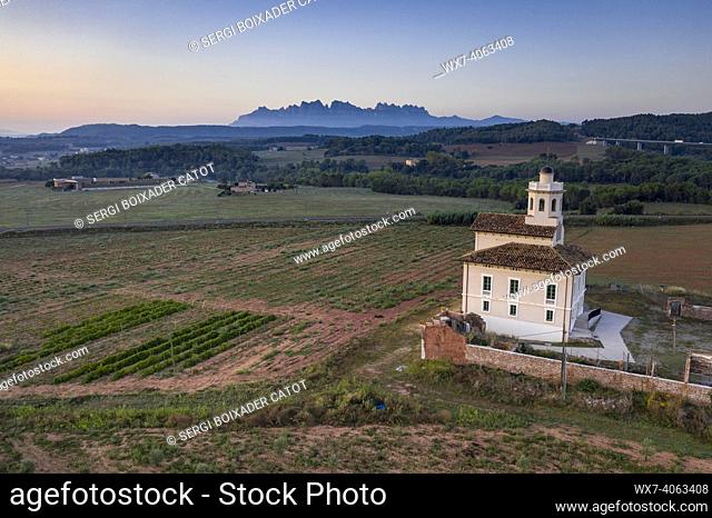 Montserrat mountain and Torre LluviÃ  de Manresa, surrounded by vineyards of the DO Pla de Bages, in an aerial view of a summer sunrise (Barcelona province