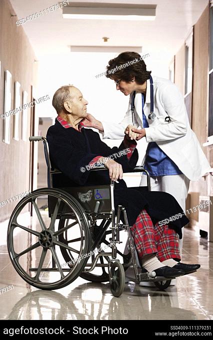 Nurse talking to an elderly man in a wheelchair