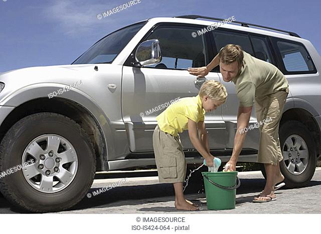 Father and son washing family car