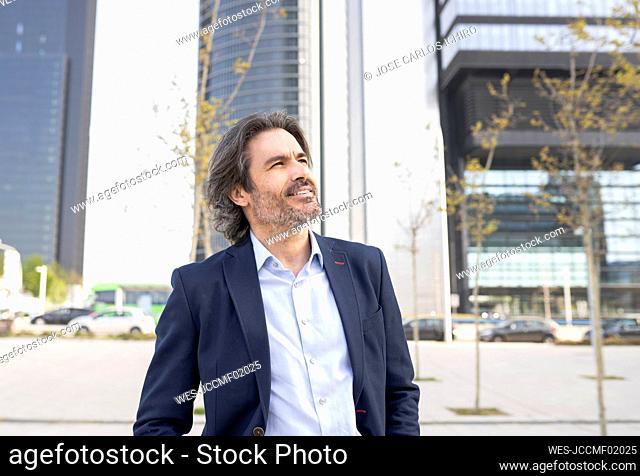 Thoughtful male entrepreneur looking away in city