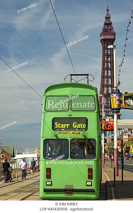 England, Lancashire, Blackpool, An electric tram travelling along Blackpool's Golden Mile with the Tower in the background