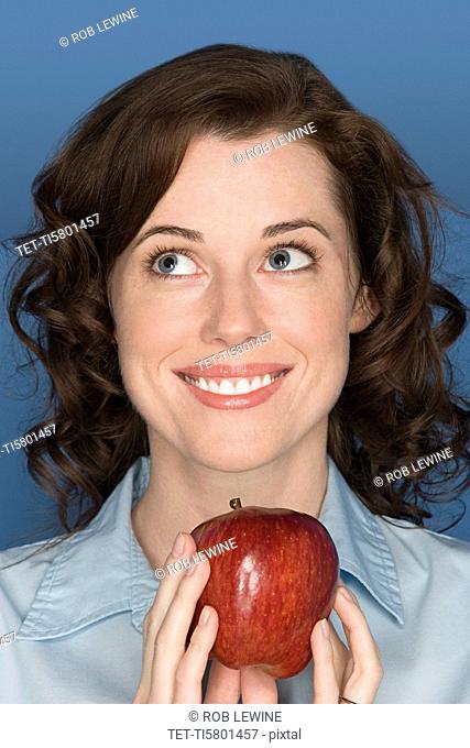 Portrait of happy mid adult woman holding apple