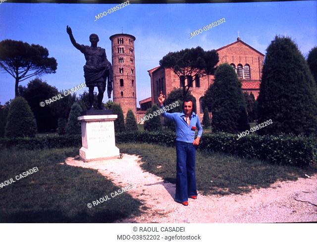 Italian musician Raoul Casadei poses in front of Basilica of Sant'Apollinare in Classe and Emperor Augusto statue. Ravenna, 1975