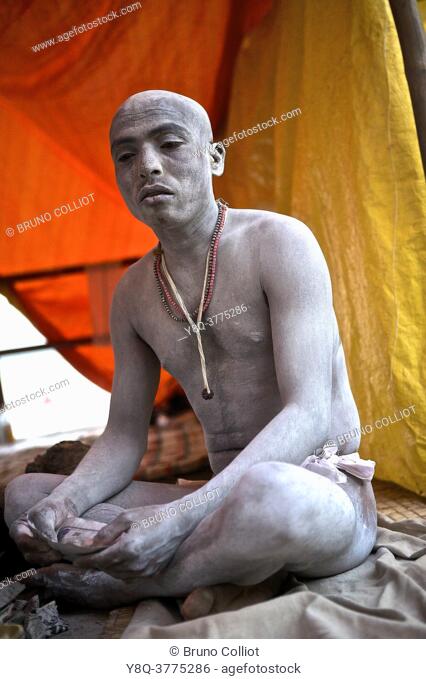 naga baba in encampment on the benares ghats after kumbh mela with the end of a cycle and the abandonment of his shaved hair