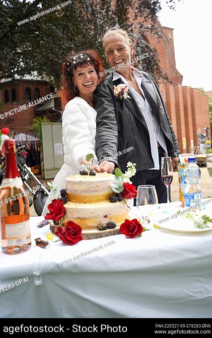 21 May 2022, Berlin: Astrid and Stefan cut their wedding cake after saying ""I do"" at a pop-up wedding in the Church of the Genezareth