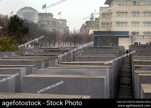 09 November 2020, Berlin: A man walks through the Holocaust Memorial in the Mitte district near the Reichstag building (l-r)