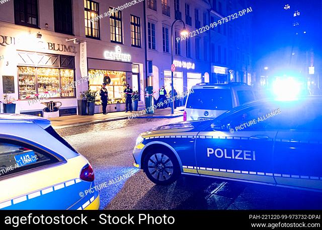 20 December 2022, Hamburg: Police vehicles stand in front of a building after a robbery at a jeweler in Neustadt. Several perpetrators robbed the store in the...