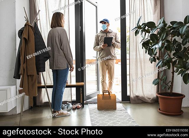 food delivery man in mask with tablet pc and woman